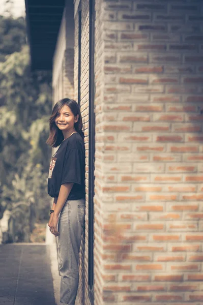 El verano, la moda y el concepto de la gente - mujer joven posando al aire libre sobre la pared de ladrillo, moda callejera — Foto de Stock