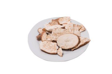 Beyaz arka plan üzerinde beyaz tabakta kuru manyok