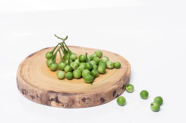 Doğrama ahşap arka plan üzerinde Türkiye berry (Solanum torvum)