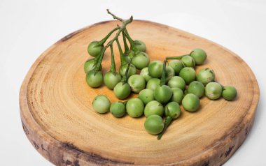 Doğrama ahşap arka plan üzerinde Türkiye berry (Solanum torvum)