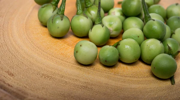 Doğrama ahşap arka plan üzerinde Türkiye berry (Solanum torvum)