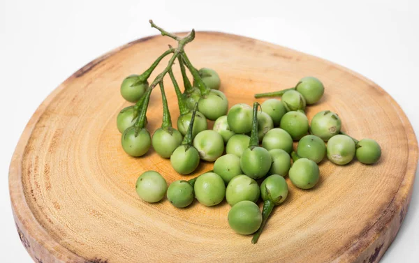 Doğrama ahşap arka plan üzerinde Türkiye berry (Solanum torvum)