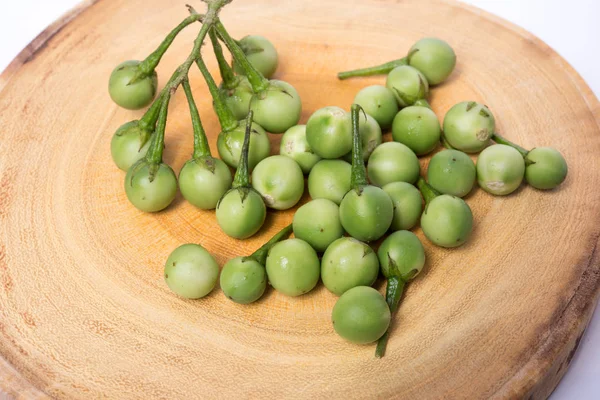 Doğrama ahşap arka plan üzerinde Türkiye berry (Solanum torvum)