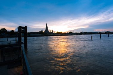 WAT Arun, Bangkok, Tayland için renkli bir gökyüzü gün batımında ile Chao Phraya Nehri kenarındaki