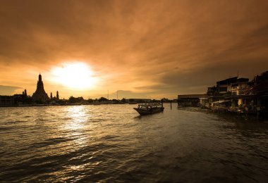 WAT Arun, Bangkok, Tayland için renkli bir gökyüzü gün batımında ile Chao Phraya Nehri kenarındaki