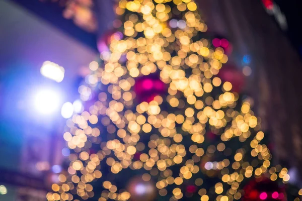 Färgglada suddiga julgran bakgrund med lampor och ornamentala dekorationer, suddig holiday bakgrund — Stockfoto