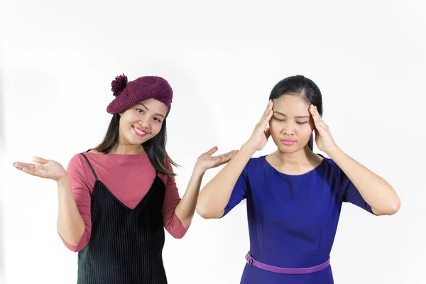 ผู้หญิงสาวเอเชียที่มีอาการปวดหัวและผู้หญิงที่มีความสุขยิ้มบนพื้นหลังสีขาว — ภาพถ่ายสต็อก