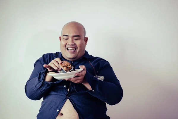 fat man eating, portrait of overweight person feels hungry and eating chips,cake,green tea frappe seated on armchai, isolated on white background with clipping path