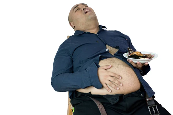 şişman adam kilolu kişinin portre yemek, aç hissediyor ve izole kırpma yolu ile beyaz arka plan üzerinde yemek fişleri, kek, armchai üzerinde oturmuş yeşil çay frappe