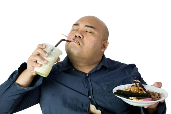 Fat man eating, portrait of overweight person feels hungry and eating chips,cake,green tea frappe seated on armchai, isolated on white background with clipping path — Stock Photo, Image