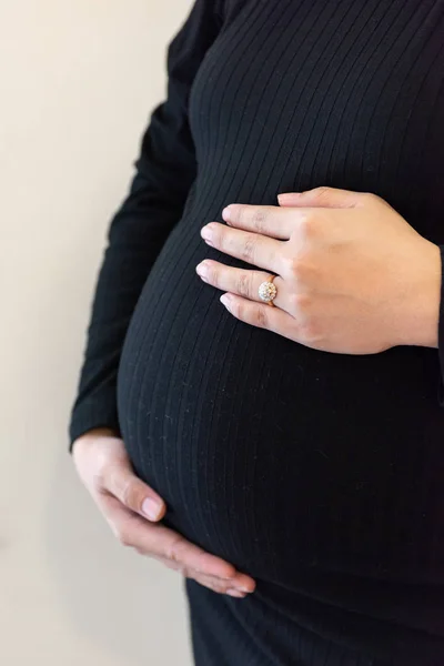 Mujer embarazada sintiendo al bebé. Joven embarazada sostiene su —  Fotos de Stock