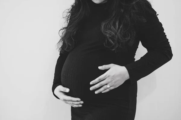 Pregnant woman feeling the baby. Young pregnant woman holds her — Stockfoto