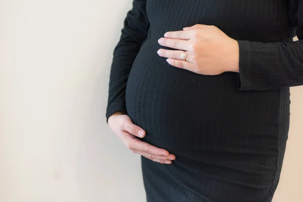 Una donna incinta che sente il bambino. Giovane donna incinta tiene le mani sul suo ventre gonfio. Concetto amore. — Foto Stock