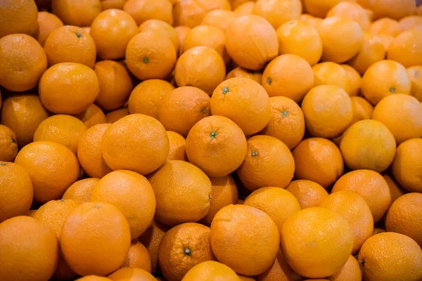 Lots of fresh mandarin oranges at market place. Oranges background