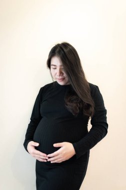 Hamile, mutlu bir kadın karnına dokunuyor. Hamile orta yaşlı anne portresi.