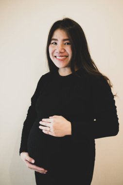 Hamile, mutlu bir kadın karnına dokunuyor. Hamile orta yaşlı anne portresi.