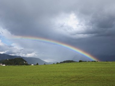 Alp manzara güzel gökkuşağı ile. Dağlar, çayır ve Mera sunbow ile.