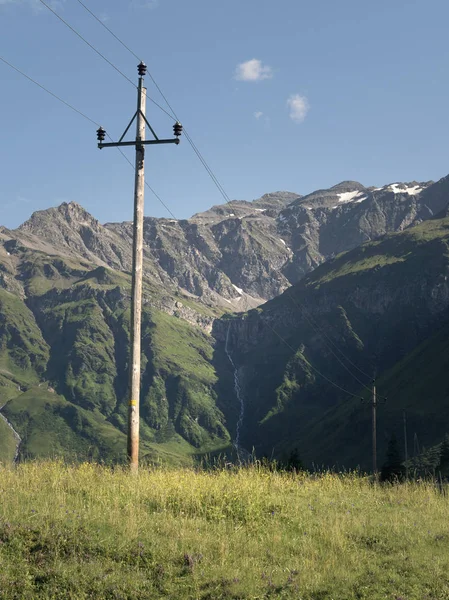 Festői alpesi sziklás alpesi völgy a Sportgastein nyáron sor távvezetékek és villamosenergia-pólus a. — Stock Fotó