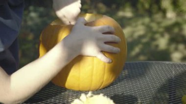 Küçük çocuk kaşık Halloween korkunç kafa sıvazlar. Cadılar Bayramı Balkabağı korkuluk çocuk elleri bölmek.