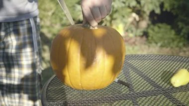 Babası Halloween korkunç kafa bıçakla açmaktadır. Adamın elleri bıçak kabak ürkütücü ağız diş ile carve..