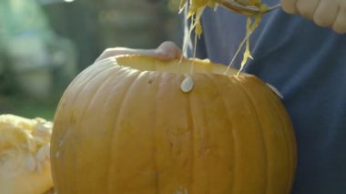 Küçük çocuk kaşık Halloween korkunç kafa sıvazlar. Cadılar Bayramı Balkabağı korkuluk çocuk elleri bölmek.