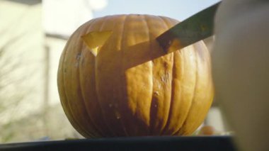 Babası Halloween korkunç kafa bıçakla açmaktadır. Adamın elleri bıçak kabak ürkütücü ağız diş ile carve..