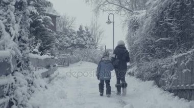 Kadın ve erkek çocuk, köy kar felaket yürüme ile dağ town karlı sokak. Kış manzarası, düşen kar. Her şey kapalı, taze tozdur. Kış atmosfer, Noel arka plan.