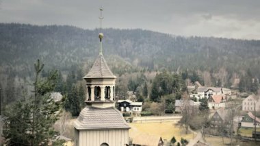 Eski ve lekeli Barok Kilisesi. Sarı çakıllı ve kuşbaşı cephe. Kilise bell ve çapraz ile küçük kule. Güneşli havalarda. Statik gün stabilize v-günlük vurdu.