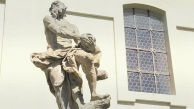 Barok kumtaşı heykel, Hristiyan Kutsal Aziz. Mavi gökyüzü ile güzel bir güneşli gün. Taş Heykel, arka planda kilise bul. Katolik dini sembolizm ve sahne