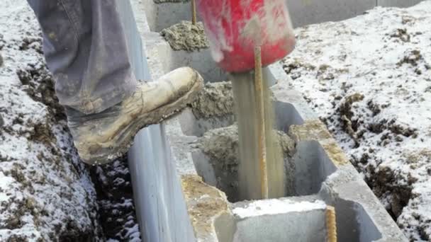 Dělníci pracují na staveniště, zemní práce. Detail čerpadla lití betonu do základů rodinného domu. Čerpadlo na beton, obloha pozadí