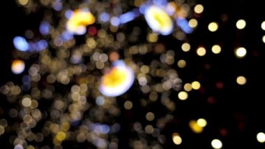 Ağaçta parlayan noel ışıklarını söndürmüş. Siyah arkaplanda soyut renk kompozisyonu. Noel dilekleri için arka plan, parlayan bokeh