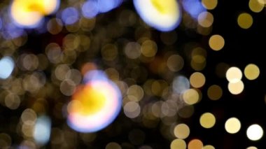 Ağaçta parlayan noel ışıklarını söndürmüş. Siyah arkaplanda soyut renk kompozisyonu. Noel dilekleri için arka plan, parlayan bokeh