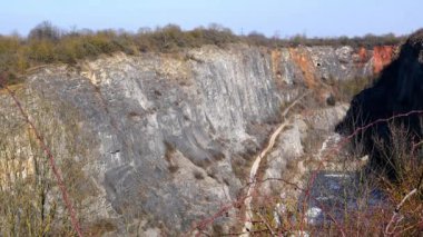 Madencilik taşı ya da diğer mineraller için kullanılan yüzey ocağı. Benimki bitki örtüsüyle kaplıydı. Maden ocağına giden yol. Göletli çakıl çıkarma ocağı