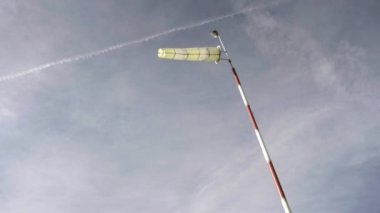 Günbatımı gökyüzü arka planında Windsock. Rüzgarda parlayan hava durumu aleti. Meteoroloji rüzgâr çorabı, rüzgar hızı