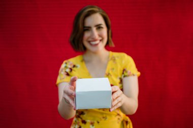 Elinde hediyeyle gülümseyen kadın.