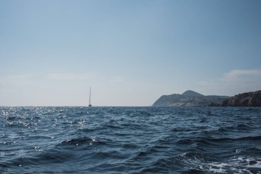 Denizin ufuklarında dalgalarla dolu bir gemi. Gökyüzü ve okyanus