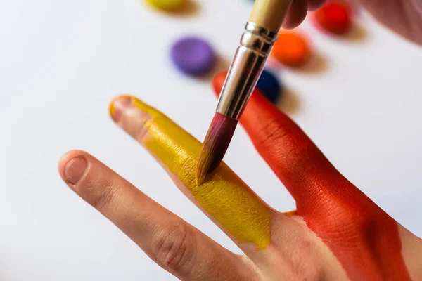 Närbild Person Som Målar Sin Hand Med Gula Och Röda — Stockfoto