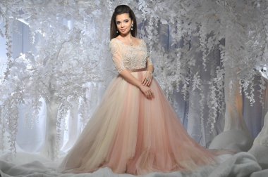 Beyaz ağaçlar kış arka plan ile uzun elbiseli güzel esmer model kız