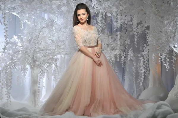 Beyaz ağaçlar kış arka plan ile uzun elbiseli güzel esmer model kız