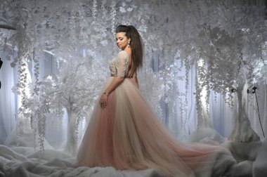 Beyaz ağaçlar kış arka plan ile uzun elbiseli güzel esmer model kız