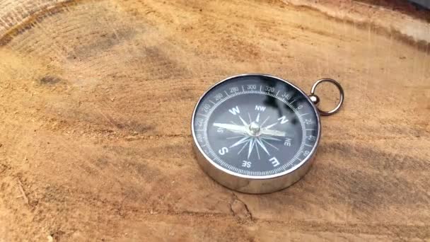 Mänsklig hand att sätta på en stubbe metall kompass — Stockvideo