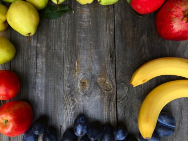 Nar, armut, muz, elma ahşap arka plan üzerinde