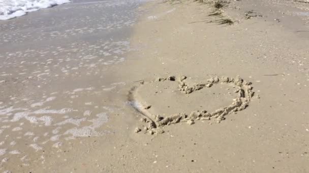 Malované srdce v písku na pláži smývá vlna — Stock video