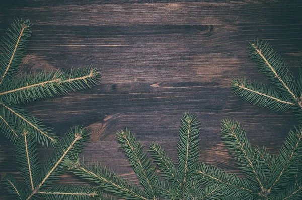 Ramas de abeto sobre superficie de madera marrón, fondo navideño — Foto de Stock