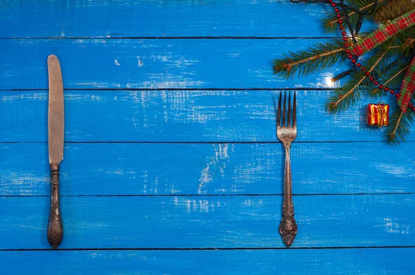 Silver knife and fork on a blue wooden background