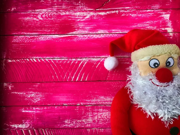 Hem de çok alacalı ahşap pembe bir arka plan üzerinde Noel Noel Baba — Stok fotoğraf