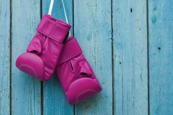 Gants de boxe roses sur fond de bois fissuré bleu — Photo