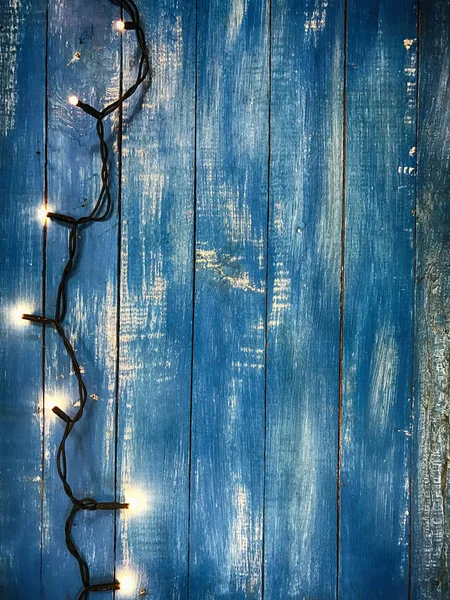 Mavi ahşap arka plan üzerinde küçük pençeleri ile elektrik garland