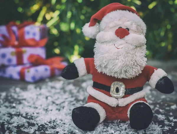 Santa Claus sobre una superficie de madera gris con nieve — Foto de Stock