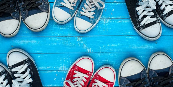 Het dragen van sneakers op een blauwe houten ondergrond, top uitzicht — Stockfoto